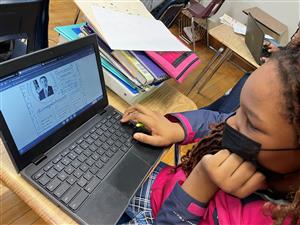 Strong Vincent sixth grade student using laptop to research Barack Obama for a Black History Month presentation.